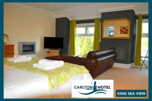 - une chambre avec un grand lit et une télévision dans l'établissement The Mumbles Carlton Hotel, à Mumbles