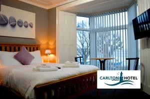 a bedroom with a bed with towels on it at The Mumbles Carlton Hotel in The Mumbles