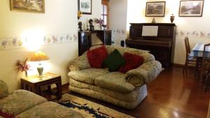 a living room with a couch and a piano at Sunnyside B&B in Balloch