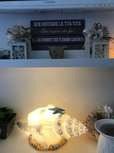 a seashell lamp on a table with a sign at Cima Bianca in San Vito lo Capo