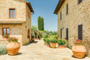 a courtyard with large pots of plants in a building at Sole del Chianti in Tavarnelle in Val di Pesa