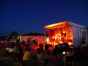 a crowd of people sitting in chairs in front of a stage at Camping Officiel Siblu Les Sables du Midi in Valras-Plage