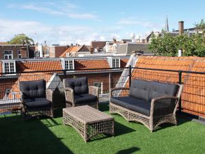 - un balcon avec une table et des chaises dans l'établissement Pearl of the Hague - R.Q.C., à La Haye