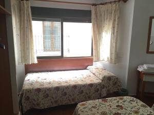 1 Schlafzimmer mit 2 Betten und einem Fenster in der Unterkunft Pensión El Hidalgo in Granada