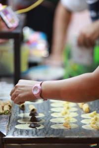 a person reaching for some food on a tray at The Port Hostel in Suratthani