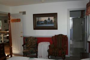 una habitación con 2 sillas y una foto en la pared en Carriage Corner Bed & Breakfast en Gordonville