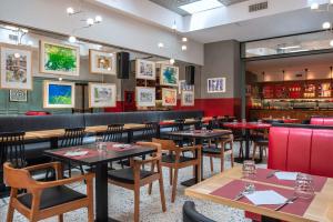 uma sala de jantar com mesas e cadeiras de madeira em Albergo Etico Roma em Roma