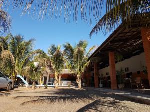 un edificio con palmeras delante en Pousada Sol Nascente ll, en Olímpia