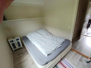 a small bed in a small room with a shelf at Nedre Amla Fjord Apartment in Kaupanger