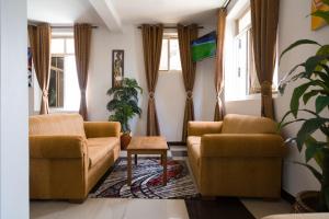 sala de estar con 2 sillas y mesa en Two Mountains Lodge en Arusha