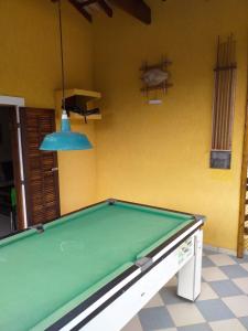 a pool table in front of a yellow wall at Pousada Maui in Ubatuba