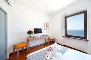 a bedroom with a bed and a desk and a window at Arpaiu in Manarola