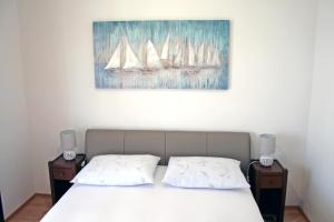 a bedroom with a bed with two night stands and a painting at Apartments Villa Zvonimir in Slatine