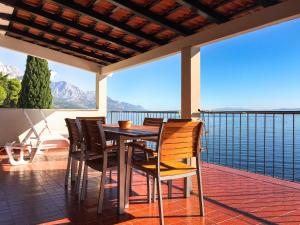 una mesa y sillas en un balcón con vistas al agua en Villa Antares Pisak, en Pisak