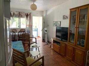 a living room with a television and a dining room at El jardín de La Isleta in La Isleta del Moro