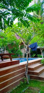 a swimming pool with a bench and a tree at Santai Retreat in Kuta Lombok