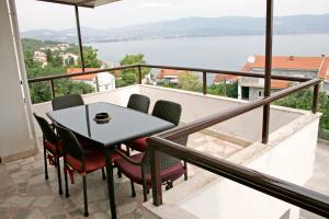 a balcony with a table and chairs and a view of the water at Apartments Villa Zvonimir in Slatine
