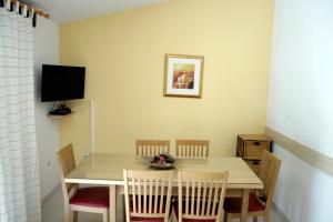 a dining room table with chairs and a television at Apartments Villa Zvonimir in Slatine