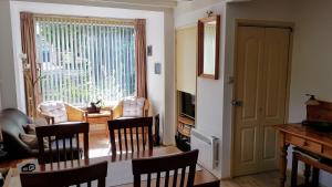 een woonkamer met een tafel en stoelen en een raam bij het Pelikaantje in Werkhoven