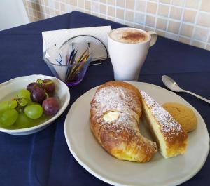 a table with a plate of pastries and a cup of coffee at Coccinella in Sabaudia