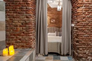 ein Schlafzimmer mit einem Bett und einer Ziegelwand in der Unterkunft Luxury Apartment museum mile. Air condicioning in Madrid