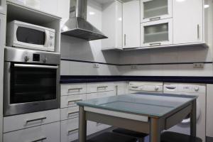 une cuisine avec des placards blancs et une table. dans l'établissement Luxury Apartment in Plaza de España, à Madrid