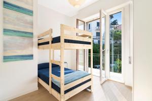 a bedroom with bunk beds in a room with a window at Casa Babette by PortofinoHomes in Rapallo