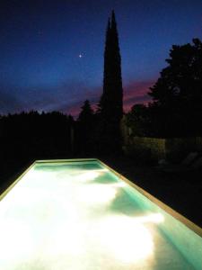 Aigaliers的住宿－le mas du cypres, 12 pers et piscine，空的游泳池,晚上有天空
