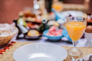 a glass of orange juice next to a plate of food at Dar Widad in Ouarzazate