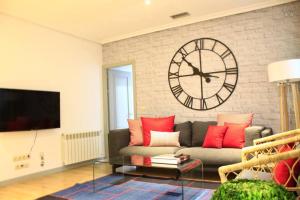 un salon avec une grande horloge sur un mur de briques dans l'établissement Luxury Apartment in Plaza de España, à Madrid