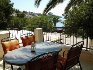 a table and chairs on a balcony with a view of the ocean at Apartments Lena in Podgora