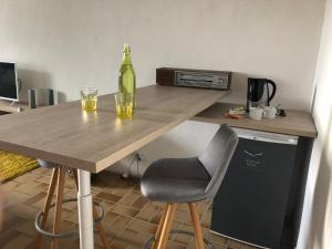 L'ÉPERVIER BLANC في Habère-Poche: طاولة خشبية مع كأسين وزجاجة من النبيذ