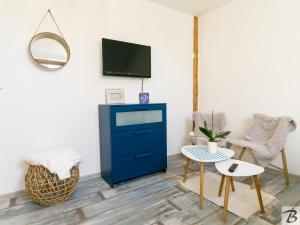 ein Wohnzimmer mit einer blauen Kommode und einem TV in der Unterkunft Apartmán u Lípy in Kamenice nad Lipou