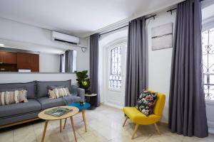 ein Wohnzimmer mit einem Sofa und einem gelben Stuhl in der Unterkunft LEEWAYS APARTMENT I in GRAN VÍA in Madrid
