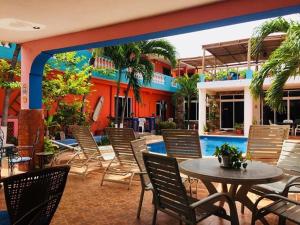 un patio con sillas, una mesa y una piscina en Hotel Maria's Nicte Ha, en Progreso