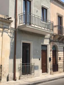 a building with balconies on the side of a street at Donna Nunzia Home in Noto