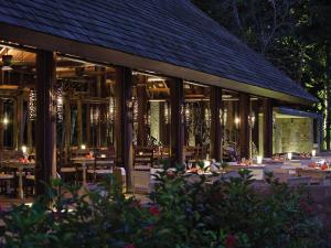 a restaurant with tables and chairs at night at Four Seasons Resort Seychelles in Baie Lazare Mahé