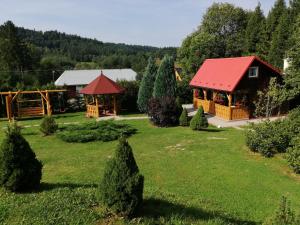a house with a red roof in a yard at Domek pod Świerkami in Czarna