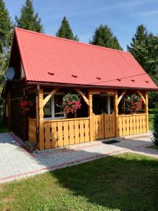 a building with a red roof and a fence at Domek pod Świerkami in Czarna