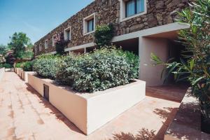 a row of bushes in front of a building at Residence Hotel Nuraghe in Porto Rotondo