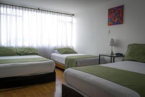 um quarto com duas camas e uma janela em Hotel Portal de Milán em Manizales