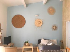 a living room with a couch and hats on the wall at La Forge in Gignac