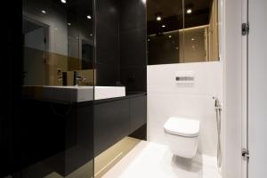 Baño en blanco y negro con aseo y lavamanos en Super-Apartamenty Andersia VIP en Poznan