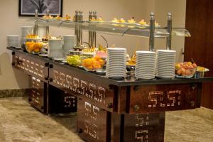 - un buffet avec des assiettes et des fruits sur une table dans l'établissement Tolip El Narges, au Caire