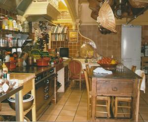 a kitchen with a stove and a table in it at Le Petit Manoir des Bruyères in Villefargeau