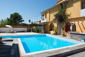 a swimming pool in front of a house at KORMORANOS BEACH in Acharavi