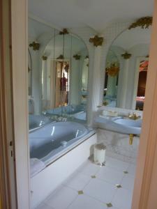 uma grande casa de banho com 2 lavatórios e uma banheira em Le Petit Manoir des Bruyères em Villefargeau