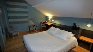 Schlafzimmer mit einem Bett, einem Schreibtisch und einem Stuhl in der Unterkunft Hôtel de charme L'Orée du Parc in Romans-sur-Isère