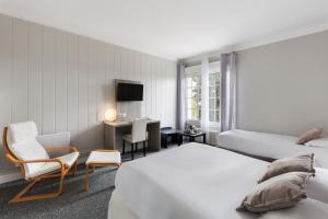 um quarto de hotel com duas camas e uma cadeira e uma secretária em Sure Hotel by Best Western Port Jérome - Le Havre em Notre-Dame-de-Gravenchon