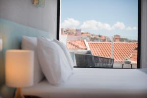 a room with a window with a view of a balcony at Reserva FLH Hotels Ericeira in Ericeira